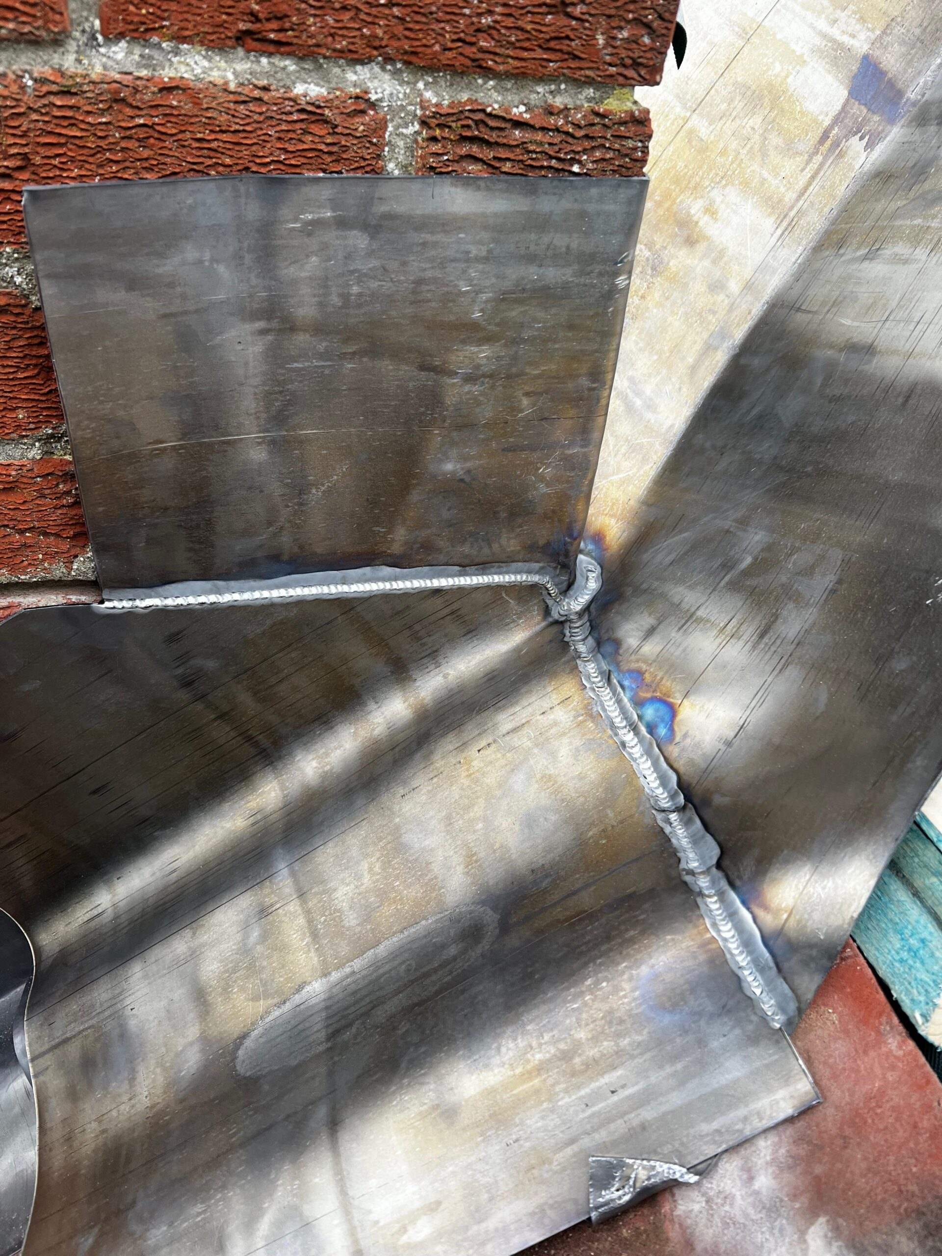 Lead flashing welded into a roof valley against brickwork