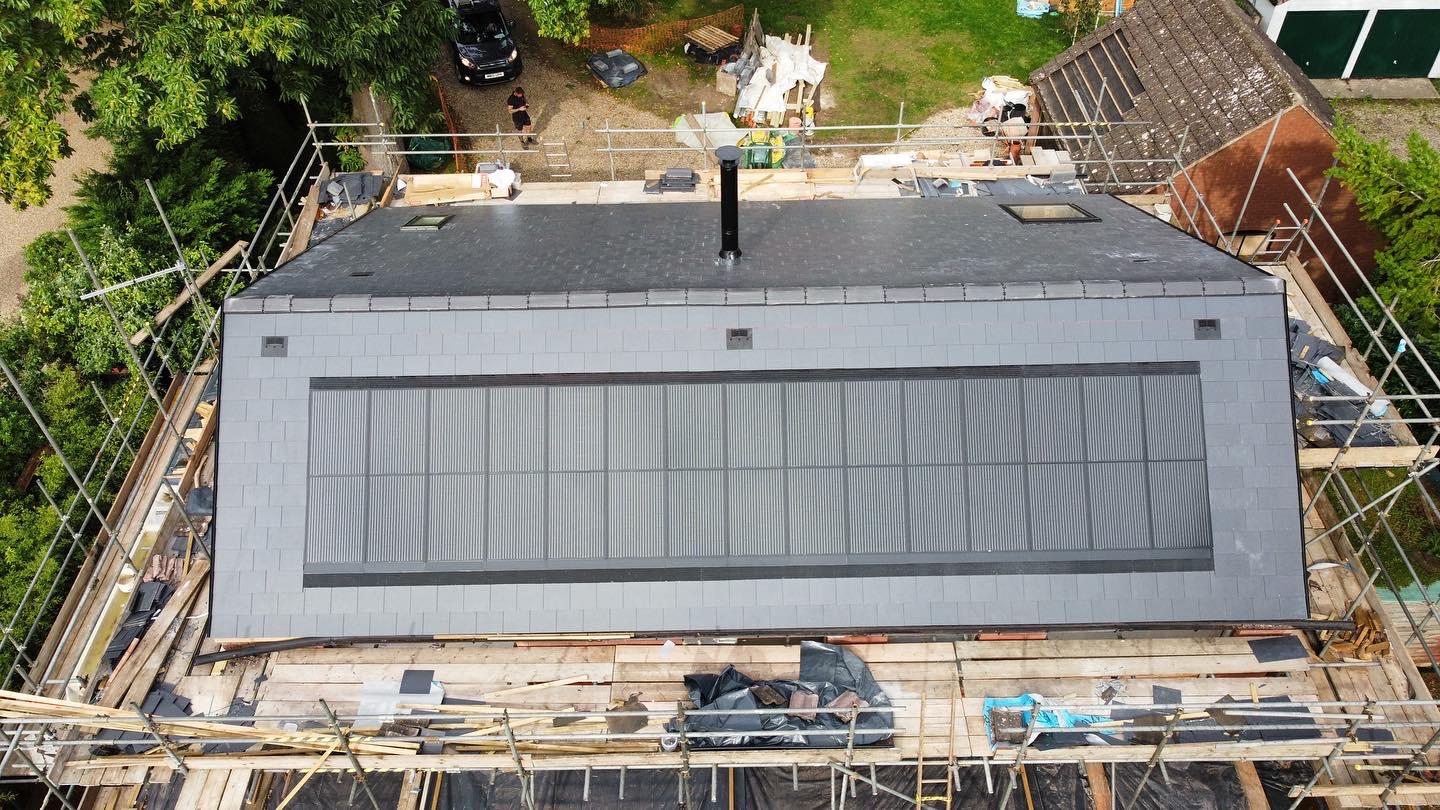 Aerial view of a flat roof with solar panels and scaffolding