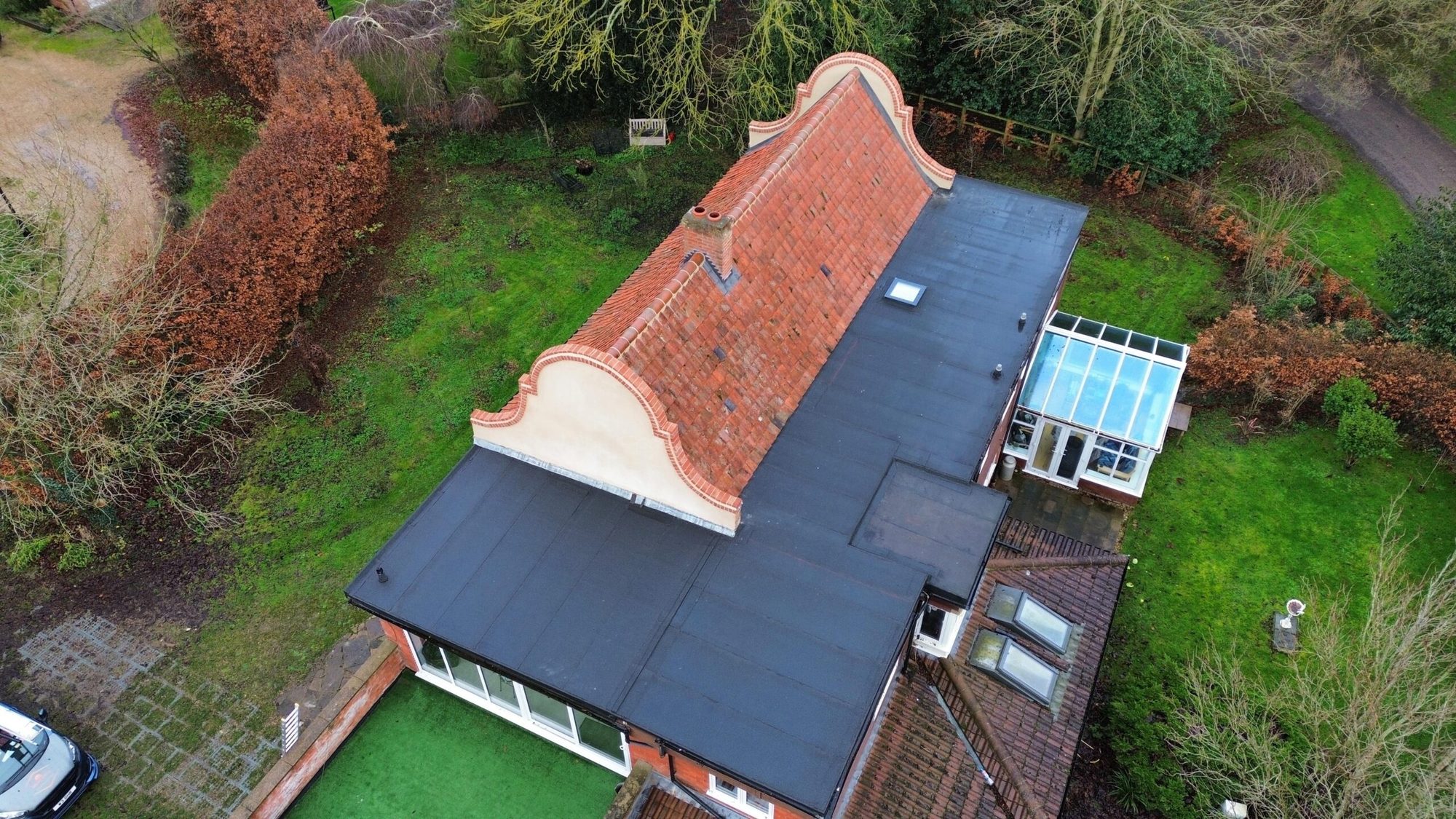Aerial view of a property with a new dark tiled roof