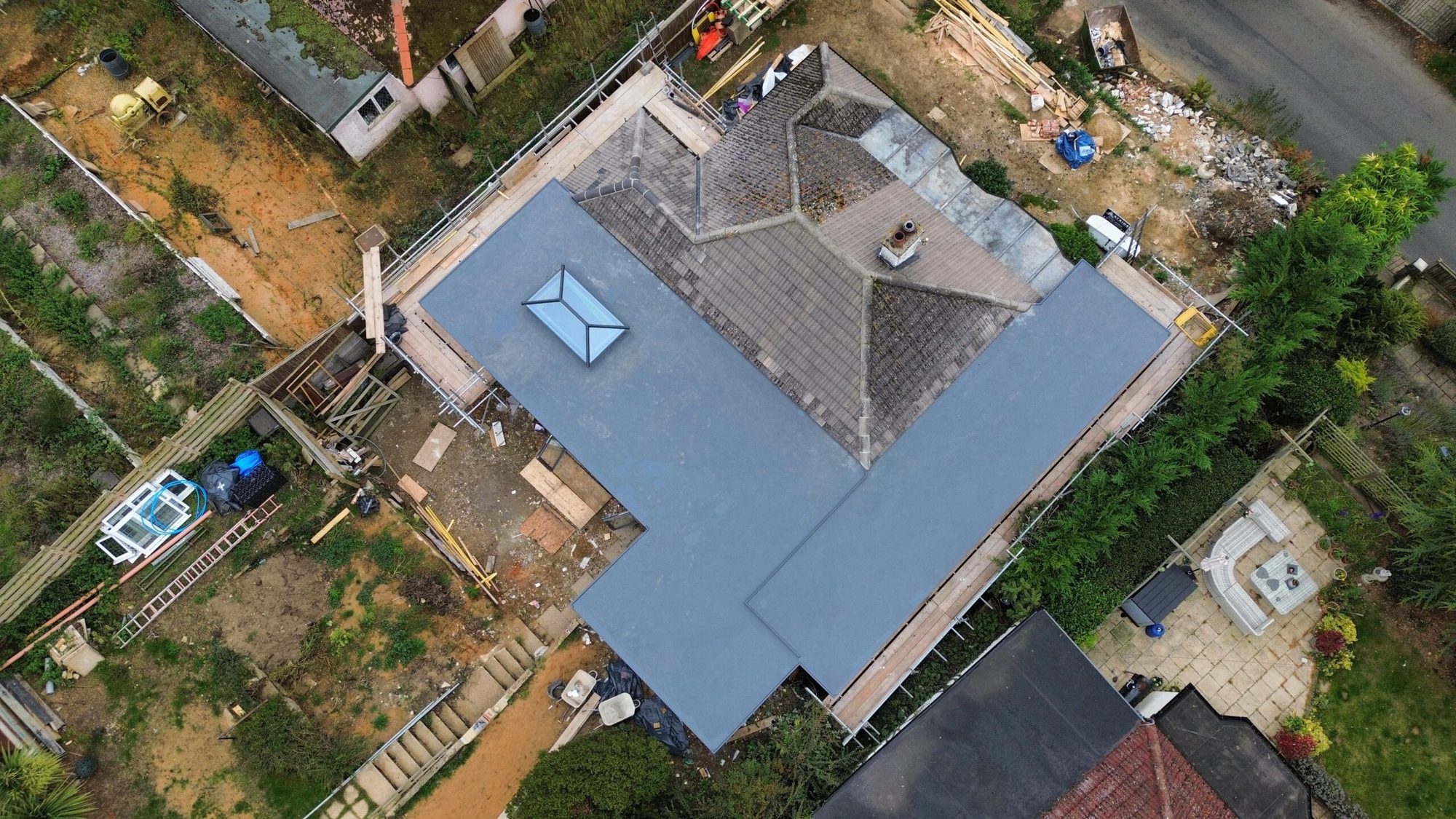 Aerial view of a bungalow with a new grey tiled roof and rooflight