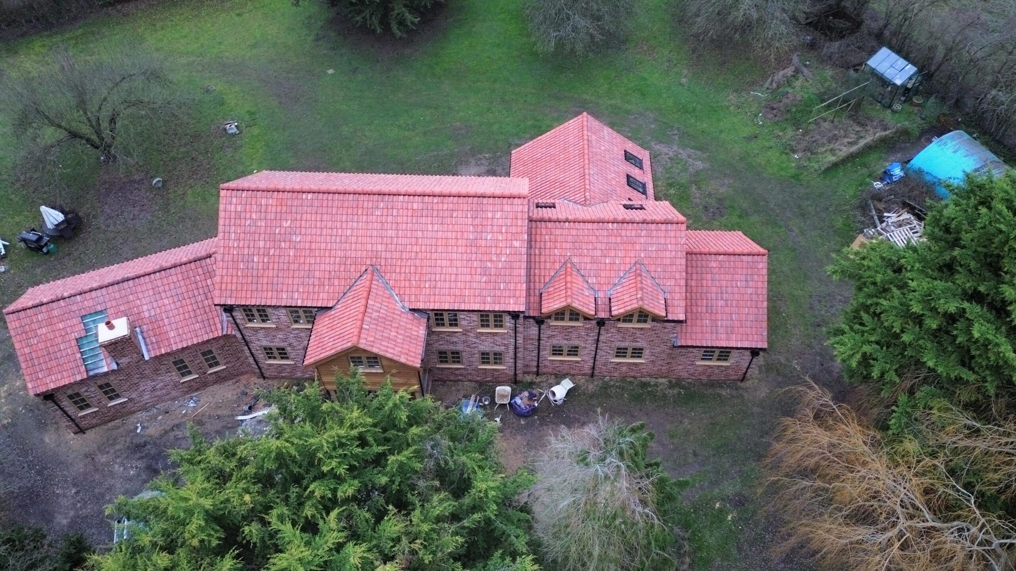 Aerial view of a large house with a newly finished red tiled roof
