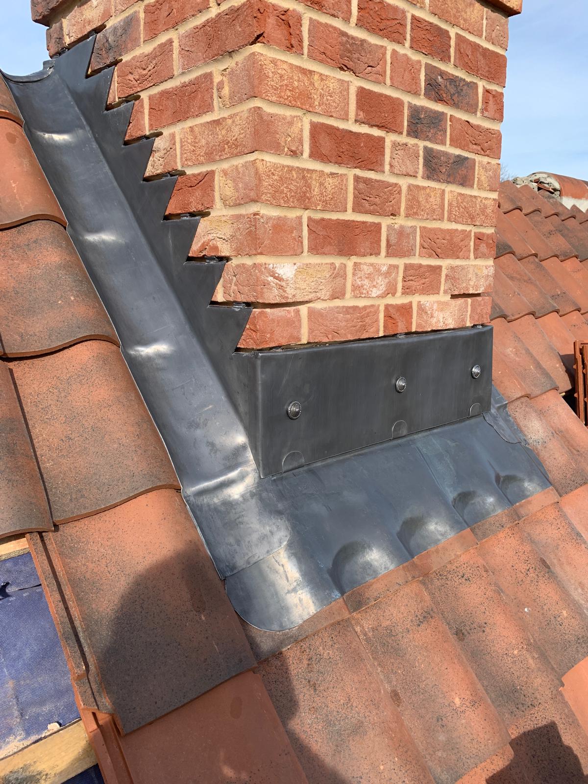 Lead flashing fitted around a brick chimney stack