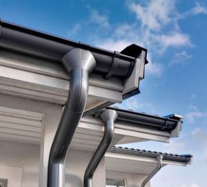 Black uPVC guttering, fascia and downpipe on a roofline